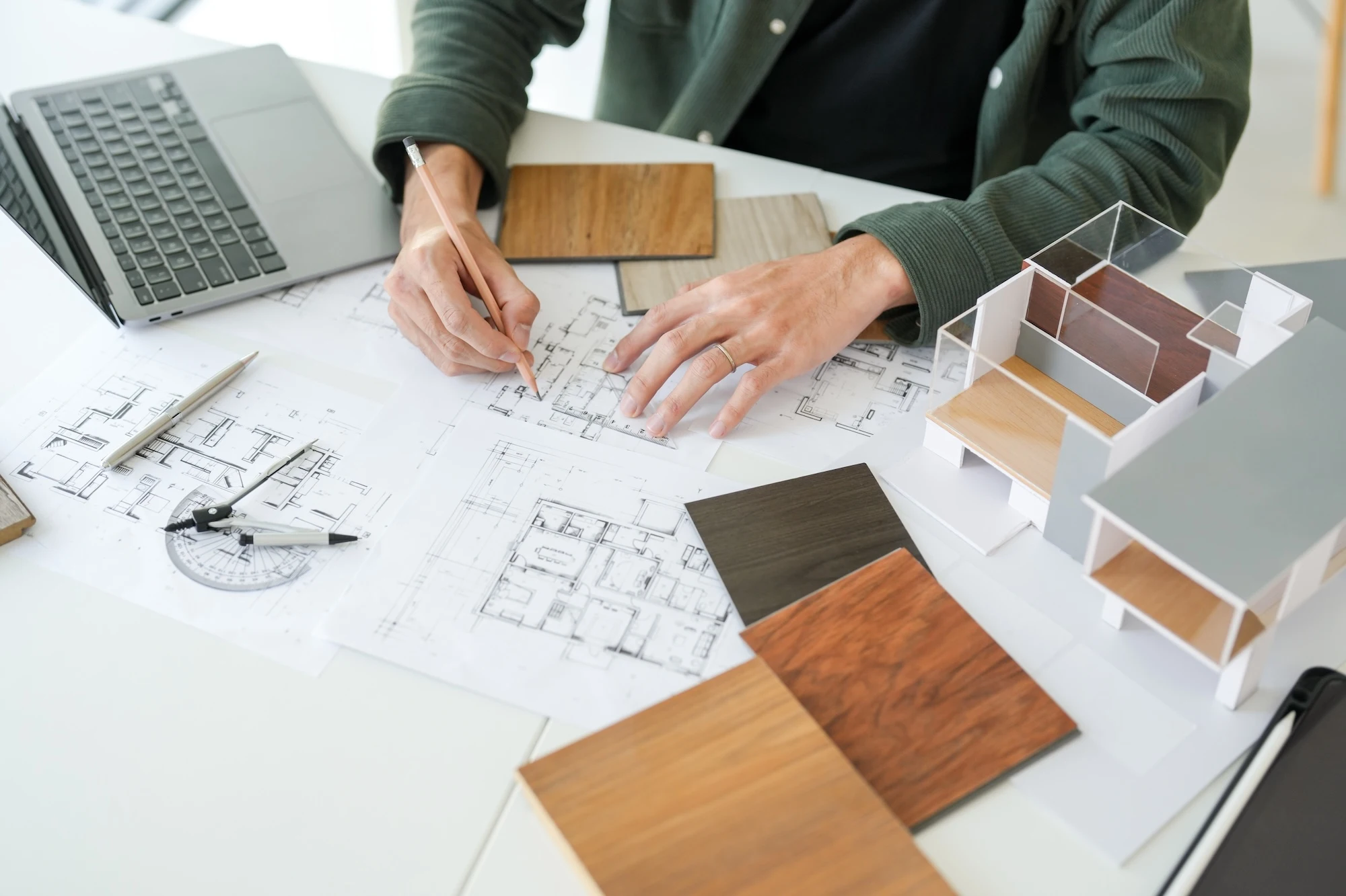 図面に描き込みながら建材サンプルと模型で仕様を検討する設計担当